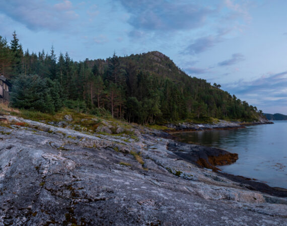 panoramic view woman reading near campfire in norway